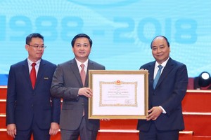 阮春福總理（右）向越南工商商業股份銀行頒授一等勞動勳章。（圖源：越通社）