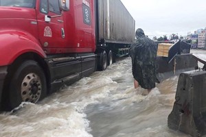 水流湍急致慶和省 1A 國道路段混凝土分隔欄被沖走。（圖源：文玉）