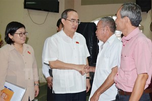 市委書記阮善仁（左二）與古芝縣選民接觸時親切握手問候。（圖源：市黨部新聞網）