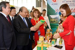 政府總理阮春福參觀農產品展。（圖源：何江）