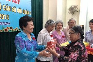 組委會向華人婦女李金梅(左)祝壽。