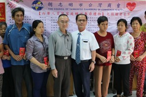 本報編委兼編輯部主任范興與台商會會長鄭文忠向第五郡華人貧困家庭贈送禮物。