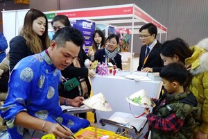 參展者觀看越南斗笠繪畫作品。