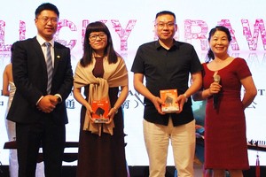 中國聯通越南總經理崔俊（左一）與中國商會本市分會秘書長吳美林（右一）向幸運兒頒發聯通產品。