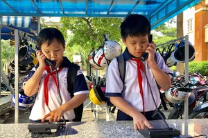 平盛郡黎文八初中校學生課後致電聯絡家長。（圖源：草心）