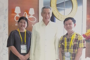 女設計師阮氏秋霞與新加坡總理李顯龍、杜孟雄藝人合照。