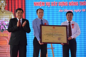 農業與農村發展部副部長陳清南（左一）向朱篤市領導轉授政府總理有關朱篤市完成建設新農村任務公認證書《決定》。（圖源：阮行）