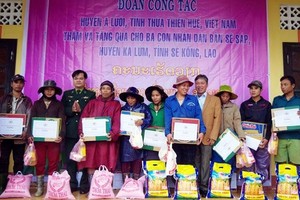 承天-順化省阿網縣工作團向老撾塞公省卡倫縣塞薩鄉民眾贈送日用品禮物。（圖源：武進）