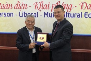 市人文社科大學副校長黎友福（左）向廣西財經學院團代表贈送紀念品。