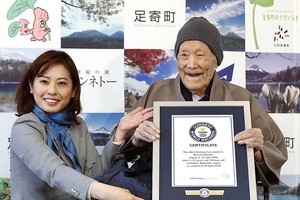 野中正造手持吉尼斯世界紀錄證書。（圖源：AP）