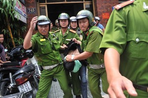 警方將抓獲的劫匪押出現場送往派出所。