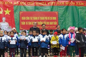 市委書記阮善仁（後排左一）探望南俊小學並向該校貧困小學生贈送禮物。（圖源：忠堅）