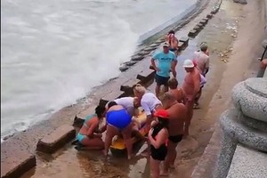 人們在給一名溺水者做人工呼吸。（圖源：L.V.Minh）