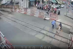 面臨列車直衝而來的一剎那，兩名鐵路女值班員奮不顧身把老人拖出了危險區域。（圖源：監控視頻截圖）