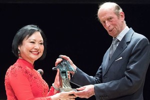潘金福（左）在德國德勒斯登市森柏歌劇院舉行的頒獎禮上，從肯特公爵愛德華王子手中接過獎座。（圖源：AFP）