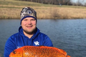 在把金魚放生前，安德森和獵物合影留念。（圖源：互聯網）