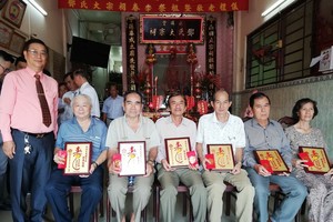 理事長鄧柏榮（左）向各宗親長老敬送祝壽利是合照。