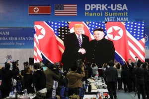 記者在國際新聞中心觀看和拍攝金正恩與特朗普會面的電視直播。（圖源：新華社）