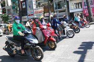 氣候炎熱，路人須在樹蔭下停車等待紅燈。