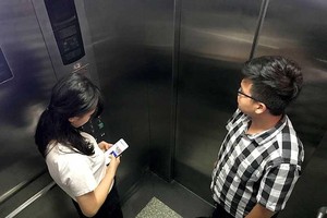 乘電梯時，不應只顧看手機。