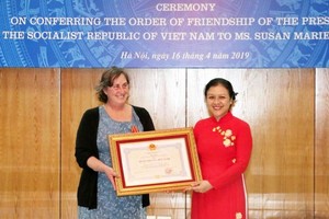 駐越南的戰爭遺產項目組織(WLP)創始人兼項目經理蘇珊‧瑪麗‧哈蒙德（左）從越南各友好組織聯合會(VUFO)主席阮芳娥手中接過獎狀。（圖源：越通社）