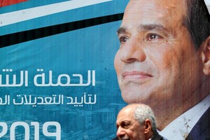 埃及開羅街頭，一名男子走過總統塞西的畫像。（圖源：路透社）