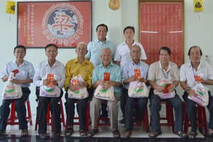 梁萬榮與梁國富正副理事長(後排)向長者們敬送禮物。