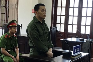 被告人何功慶站在被告席上答審判問案。（圖源：英豪）