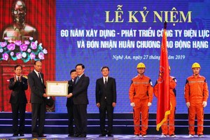 政府副總理王廷惠（前右）向乂安電力公司代表授予二等勞動勳章。（圖源：VGP）