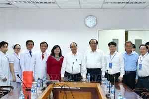 政府總理阮春福（中）與同奈省全科醫院領導、醫生和幹部合影。（圖源：越通社）