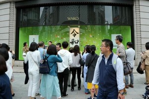 圖為東京街頭，一家商店櫥窗的“令和”字樣吸引民眾合影留念。（圖源：互聯網）