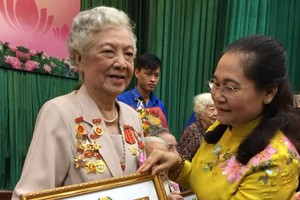 市人民議會主席阮氏麗(右)向葉秀英 大娘頒贈70黨齡紀念章。