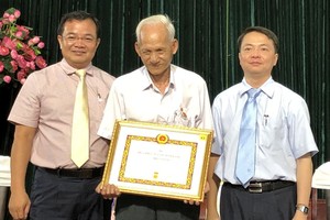 第五郡領導向華人黨員葉南如頒發50年黨齡紀念章。