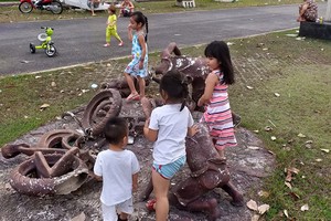 小孩們在一座壞塑像組合上玩耍。