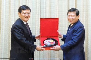 市人委會主席阮成鋒向中共中央統戰部副部長、中國全國工商聯黨組書記、常務副主席徐樂江贈送紀念品。（圖源：市黨部新聞網）