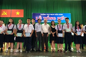 穗城會館理事長盧耀南(左七)向麥劍雄學校優秀學生頒獎。