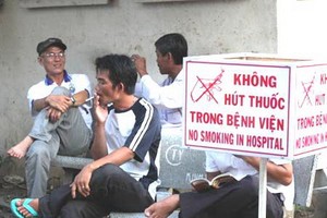 儘管醫院內設有禁煙標誌，但不少人 仍然違規吸煙。