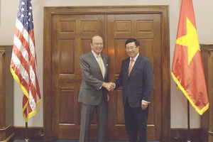 政府副總理、外交部長范平明（右）與美國商務部長威爾伯‧羅斯舉行會談。（圖源：VOV）