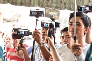 許多YouTuber 持著手機，你推我讓錄下前來探望葬禮的明星。