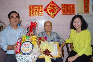 第十一郡人委會主席陳氏碧蓮（右）和郡高齡人會主席朱杞文（左）向華人長者蕭德鈞大叔贈送禮物。