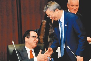 在日本福岡召開的G20財長和央行行長會議上，大陸人民銀行行長易綱（右）與美國財政部長穆努欽（左）握手。（圖源：路透社）