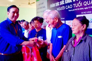 第十一郡高齡人會主任朱杞文向越華長者贈送禮物。