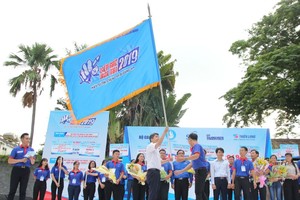 高考接力志願大學生隊伍出發儀式上遞交旗幟。