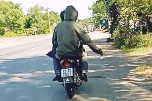 騎車載人沿路散發小廣告者受罰款。（圖源：視頻截圖）