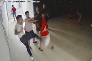 阿T 被兩名女人抓住頭髮拉到走廊並遭多名男青年施行群毆。（圖源：監控視頻截圖）