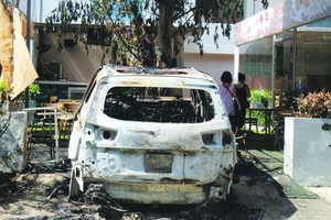 疑遭汽油彈襲擊的汽車連同車上的許多物品付諸一炬。（圖源：A. Lộc）