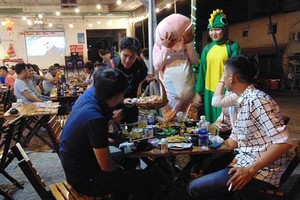 年輕人們在范文同街上的食肆扮演吉祥物和出售糖果。