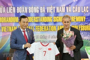 陳國俊副主席（左）向德國Wolfsburg隊大使贈送越南足球隊的衣服。（圖源：互聯網）