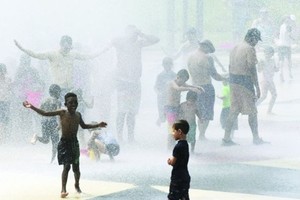 市民在噴水設施除去外衣消暑。（圖源：互聯網）