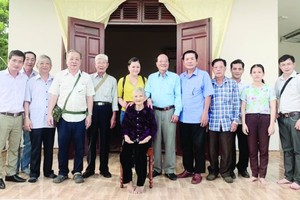 第五郡越南祖國陣線委員會及各華人會館代表與阮氏梅母親合影。